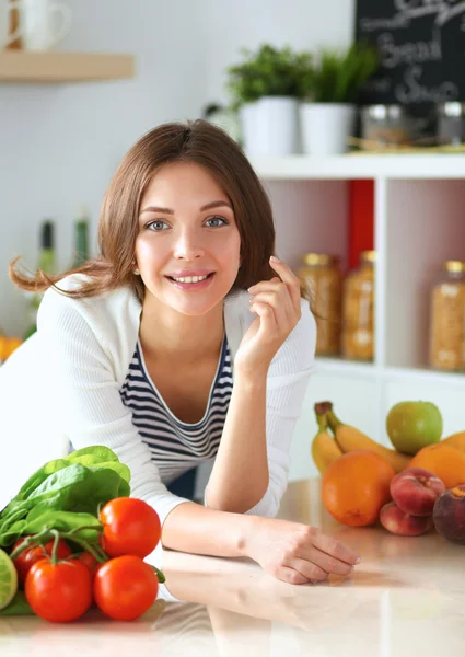 Jonge vrouw zit in de buurt van bureau in de keuken — Stockfoto