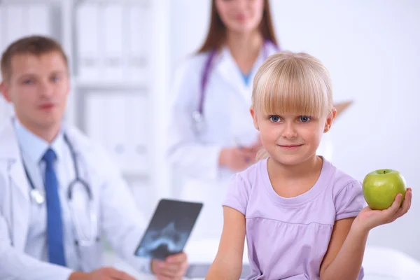 Dziecko i koncepcja medycyny - kobieta lekarz daje jabłko do uśmiechniętej dziewczynki — Zdjęcie stockowe