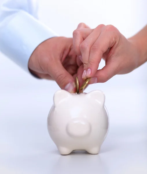 People putting coin into the piggy bank — Stock Photo, Image