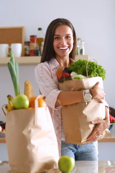 Ung kvinna som håller i matkassen med grönsaker — Stockfoto