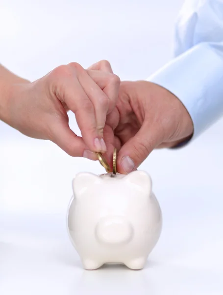 People putting coin into the piggy bank — Stock Photo, Image