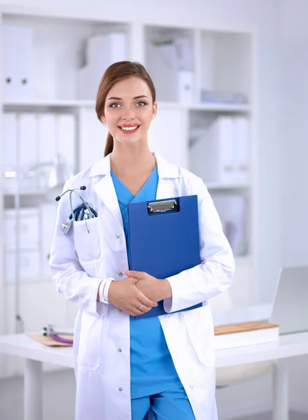 Portrait of young woman doctor with white coat standing in hospital — Stock Photo, Image