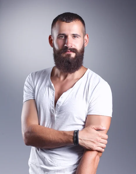 Retrato de hombre barbudo guapo de pie, aislado sobre fondo gris — Foto de Stock