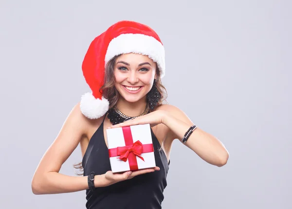 Frau mit Weihnachtsmütze mit Geschenken, isoliert auf grau — Stockfoto