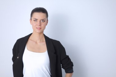 ayakta, gri arka plan üzerinde izole genç kadın