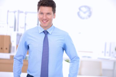 Ofiste masasının karşısında duran bir iş adamı ya da yönetici.