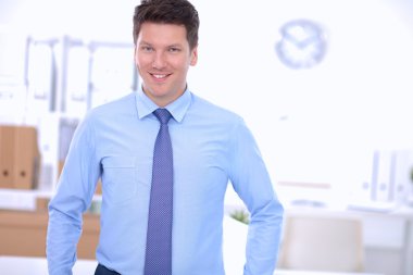 Ofiste masasının karşısında duran bir iş adamı ya da yönetici.