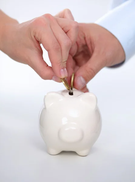 People putting coin into the piggy bank — Stock Photo, Image