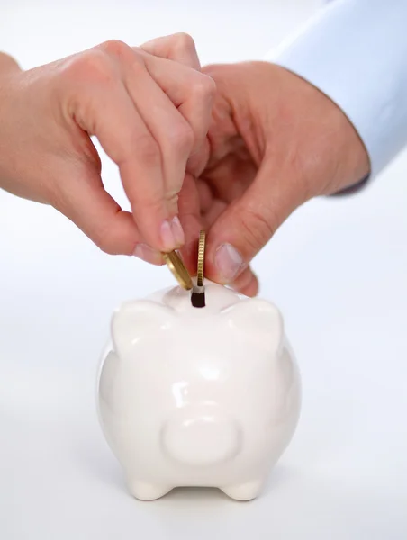 People putting coin into the piggy bank — Stock Photo, Image