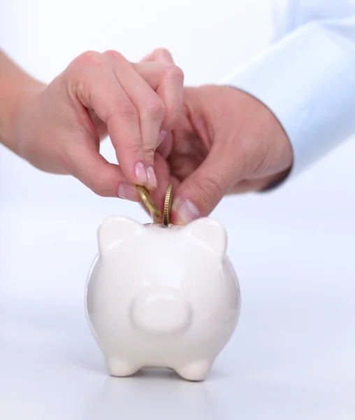 People putting coin into the piggy bank — Stock Photo, Image