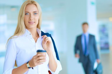 Yound kadın ayakta ofisindeki kahve içmek