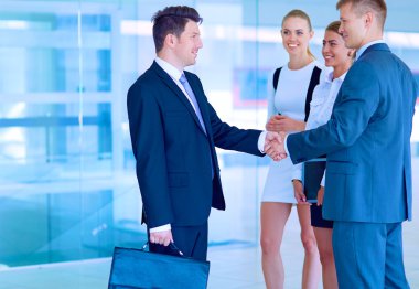 İki başarılı iş adamının el sıkışırken tam boy görüntüsü.