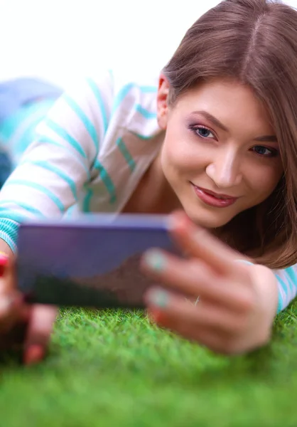 Schöne junge Frau auf grünem Gras liegend — Stockfoto