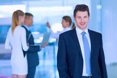 arka planda meslektaşları ile Office genç işadamı portresi