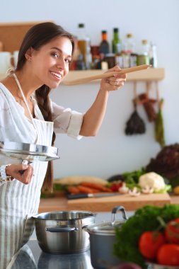 Mutfakta ahşap kaşıkla yemek pişiren kadın