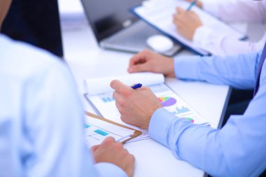 İş toplantılarında, ofiste oturan ve yazan iş adamları.