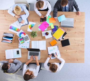 İş adamları iş toplantısında, ofiste oturup tartışıyorlar.