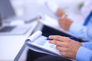 İş toplantılarında, ofiste oturan ve yazan iş adamları.