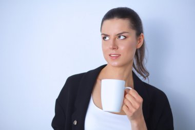 Beyaz arka plan üzerinde izole bir kupa tutan genç kadın