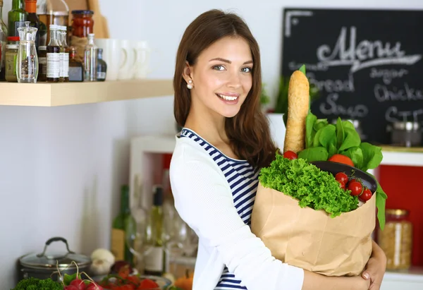 野菜と食料品の買い物袋を持っている若い女性 — ストック写真