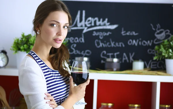 Güzel kadın mutfakta şarap içiyor. — Stok fotoğraf