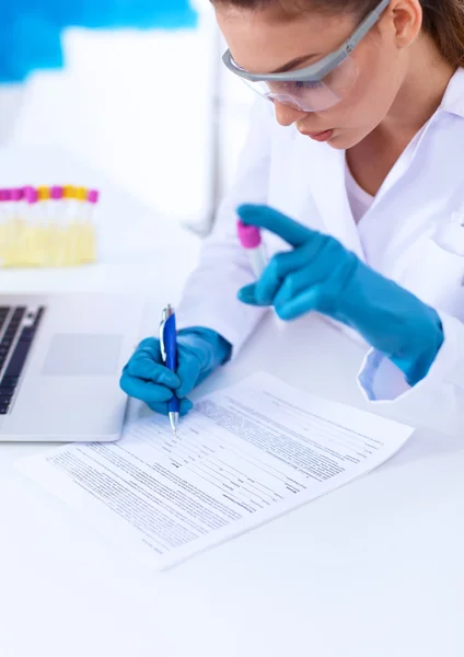 Woman researcher is surrounded by medical vials and flasks, isolated on white background — Stock Photo, Image