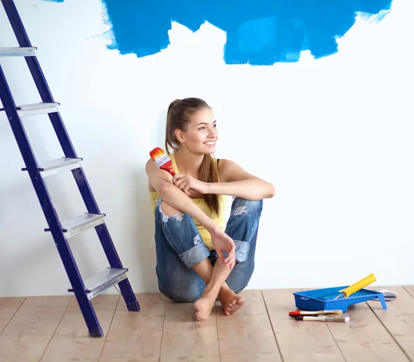 Retrato de pintora sentada en el suelo cerca de la pared después de pintar . — Foto de Stock