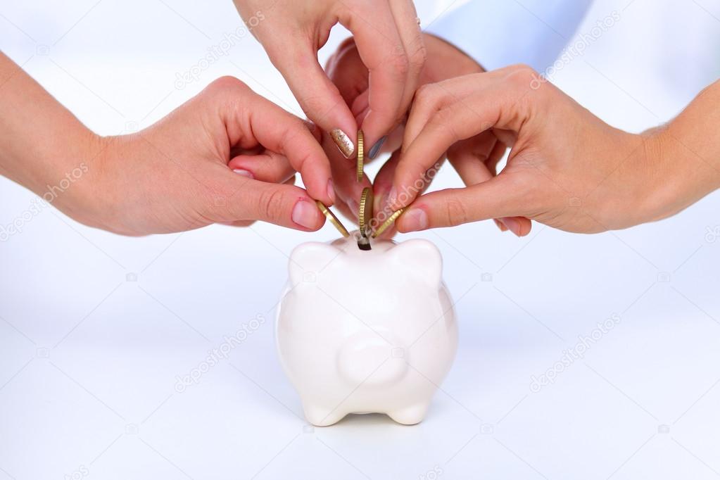 People putting coin into the piggy bank