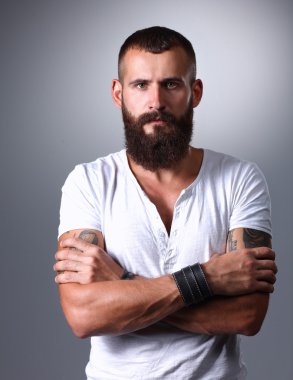 Ayakta, gri arka plan üzerinde izole yakışıklı adam portresi