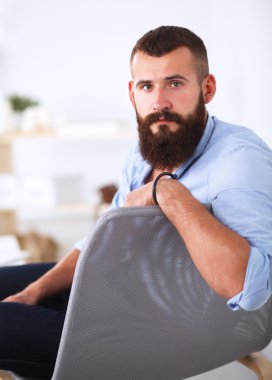 Genç işadamı koltukta oturuyor.