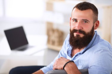 Genç işadamı koltukta oturuyor.