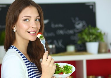 Salata yemek ve karışık salata tutan genç kadın