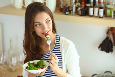 Salata yemek ve karışık salata tutan genç kadın