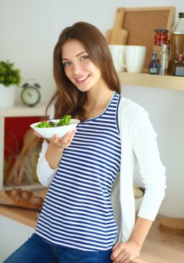 Salata yemek ve karışık salata tutan genç kadın