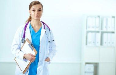 Kadın doktor hastanede dosyayla bekliyor.