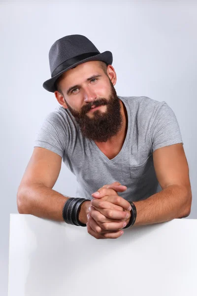 Portrait of young man in hat standing near blank, isolated on white background — Stock Photo, Image