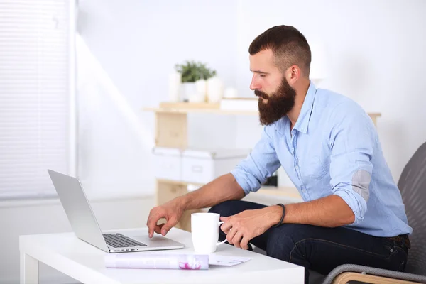 Jonge zakenman zit op stoel in functie — Stockfoto