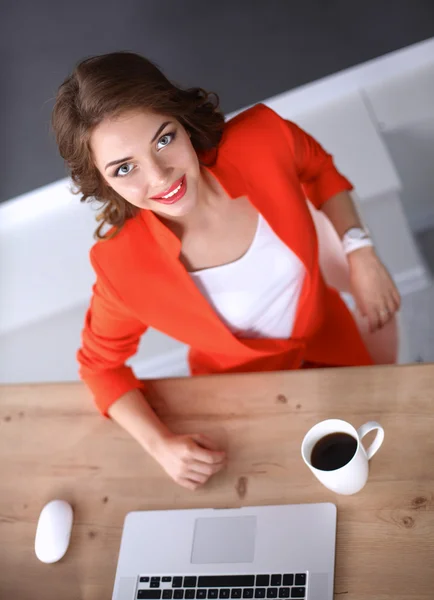 Attraktive Frau sitzt im Büro am Schreibtisch und arbeitet mit Laptop — Stockfoto