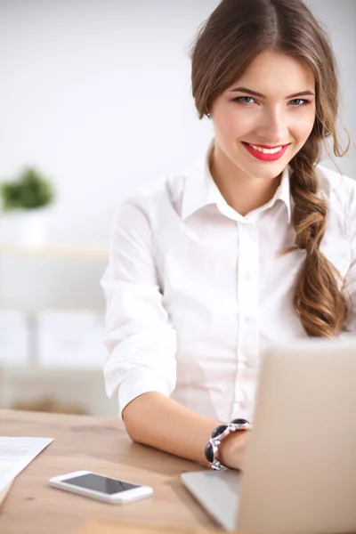 Atrakcyjna bizneswoman siedzi na biurku w biurze — Zdjęcie stockowe