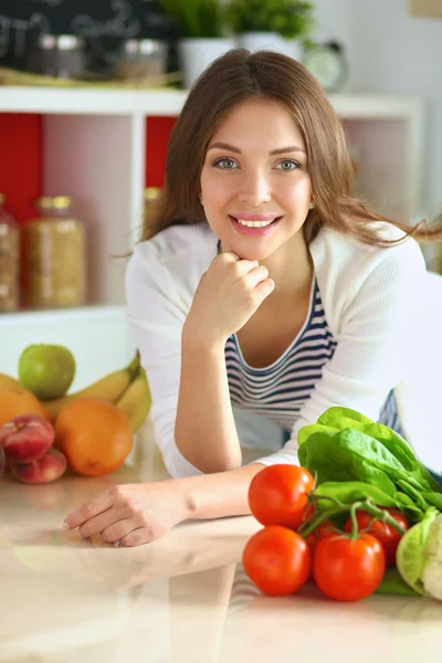 Jonge vrouw in de buurt van bureau in de keuken — Stockfoto