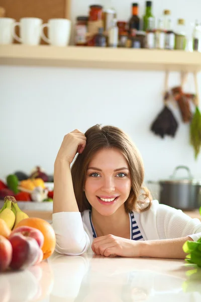 Jonge vrouw in de buurt van bureau in de keuken — Stockfoto