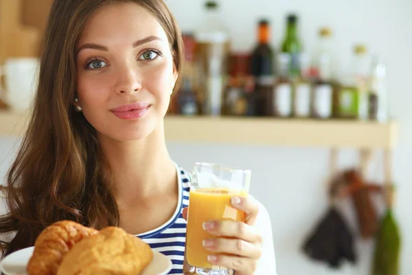 Jovem com copo de suco e bolos — Fotografia de Stock