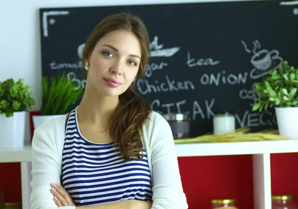 Giovane donna in piedi in cucina a casa — Foto Stock