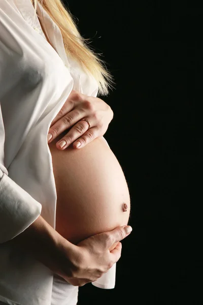 개최 그녀의 배꼽, 클로즈 업 블랙에 고립 된 임산부 — 스톡 사진