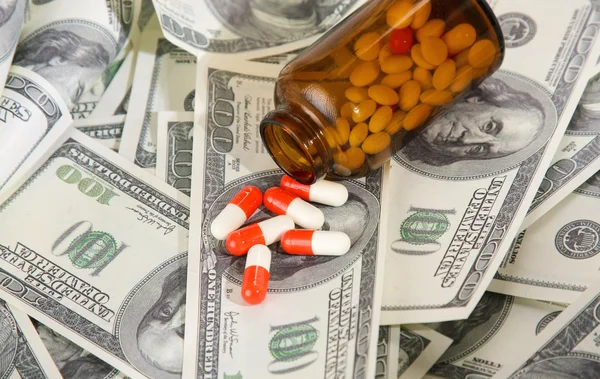 Bottle of pills and money — Stock Photo, Image