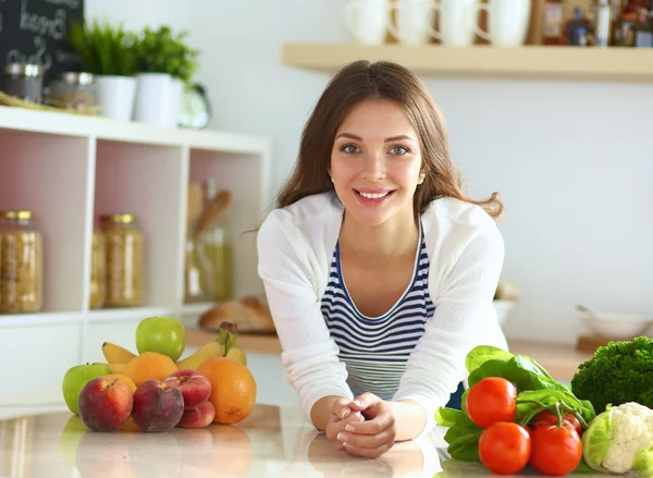 Young woman standing near desk in the kitchen — Stock Photo, Image