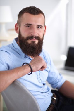 Genç işadamı koltukta oturuyor.