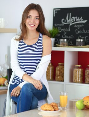 Mutfakta oturan güzel bir kadının portresi.