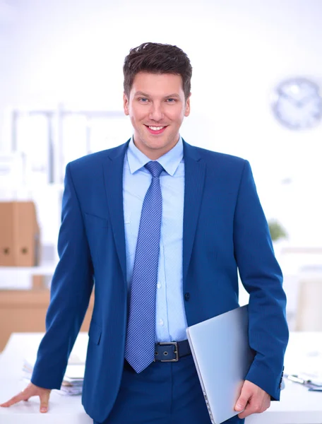 Business man or manager standing against his desk at the office — Stock Photo, Image