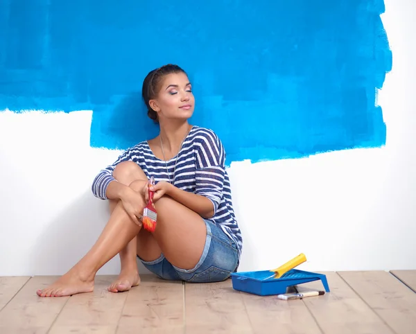 Portrait of female painter sitting on floor after painting — Stock Photo, Image